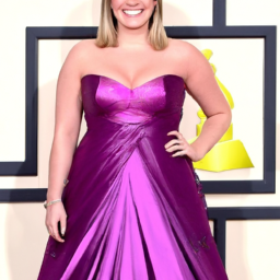 description: an anonymous image shows a confident and radiant kelly clarkson posing in a stunning strapless gown at the 2024 grammy awards, showcasing her remarkable weight loss transformation.