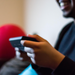 description: an anonymous image of a person holding a nintendo switch console with a smile on their face. they appear to be playing a game and enjoying themselves. the background is blurred and nondescript, focusing solely on the person and the switch.
