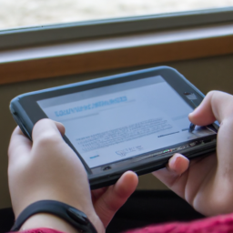description: An anonymous person is holding a Nintendo Switch in handheld mode, with the screen displaying a fanfiction story on AO3. The person's hands are typing on the touch screen, and there is a look of concentration on their face.